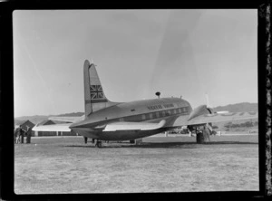 Back view of visiting British Vickers Viking passenger plane G-AJJN with unidentified men at [Paraparaumu Airfield, Wellington Region?]