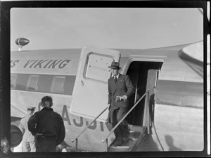 View of Mr R Gardiner (Chief Administrations Officer for NZ NAC) disembarking from visiting British Vickers Viking passenger plane G-AJJN demonstration flight, location unknown