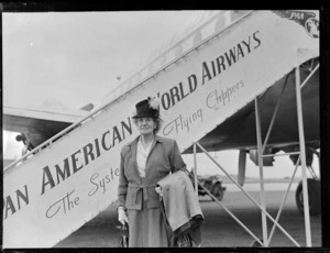 Portrait of Mrs Laura Turner in front of a Clipper Class Pan American World Airways aeroplane and gangway, Whenuapai Airfield, Auckland