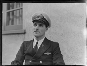 Portrait of Captain Jack Burgess in uniform, TEA (Tasman Empire Airways) in front of an unknown building, [Auckland City?]