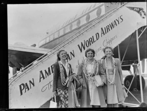 Portrait of (L to R) Miss Helen Desha, Mrs Marion Desha and Miss Nina Desha in front of a Clipper Class Pan American World Airways aeroplane and gangway, Whenuapai Airfield, Auckland