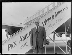 Portrait of an unidentified older man in front of a Clipper Class Pan American World Airways aeroplane and gangway, Whenuapai Airfield, Auckland