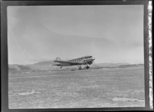 View of NZ NAC (National Airways Corporation) Dakota ZK-AOJ transport plane taking off from Paraparaumu Airfield, Wellington Region