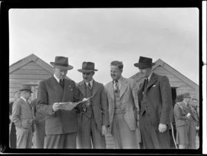 NZ NAC (National Airways Corporation) officials (L to R) Mr J Gardiner and Mr Johnson with unidentified people during an open-day to view visiting British Vickers Viking passenger plane G-AJJN at Paraparaumu Airfield, Wellington Region