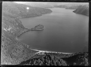 View of Lake Okataina surrounded by bush with Tauranui Bay and Okataina Lodge in foreground, Rotorua District