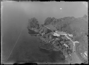 Home with garden and jetty flanked by bush on the bank of unidentified lake, Rotorua District