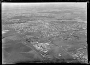 Passenger Transport Company coverage over the suburb of Otahuhu with an unknown factory, the Great South Road and Manukau Harbour in the foreground, looking to East Tamaki, Auckland City