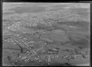 Passenger Transport Company coverage with general views over an outer unidentified [Auckland?] suburb with train station, roads and houses, surrounded by farmland