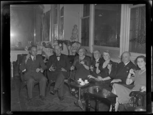 Sir E Davis with unidentified group, including women, during a party at the Grand Hotel, Auckland
