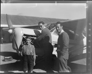 View of (L to R) R Bush (Otago), D Grieg and Brian [Coates?] (Otago) in front of Auster J-1B Autocrat ZK-AOB passenger plane, Otago Region