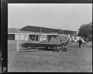 View of Otago Aero Club's De Havilland DH 82A Tiger Moth 'Chocolate Plane' ZK-AJE with unidentified men, Otago Region