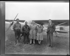 Portrait of unidentified people in front of Auster J-1B Autocrat ZK-AOB passenger plane at Sherwood Downs, Canterbury Region