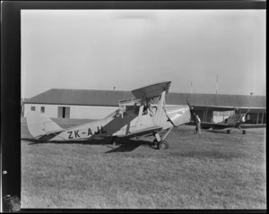View of two Otago Aero Club's De Havilland DH 82A Tiger Moths, ZK-AJL in front and KZ-AJE 'Chocolate Plane' behind, with unidentified men, Otago Region