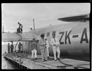 Passengers leaving Tasman Empire Airways flying boat, RMA New Zealand ZK-AME in Fiji, individuals identified - Sir Hugh Ragg MLC (left) and Mr J F Grant MBE at rear, C H G Hanson (Managing Director of Jooing Loong Company)