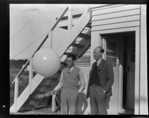 E Good (President Greymouth Aero Club) (left) with a large balloon and G Bowman, Hokitika [airport?]