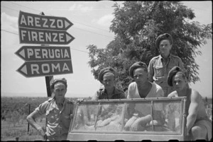 Some New Zealanders who took part in the advance at Lignano alonside a signpost in Italian forward area, World War II - Photograph taken by George Kaye