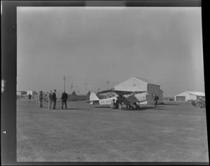 Unidentified men looking at a Auster ZK-AOB airplane, Invercargill
