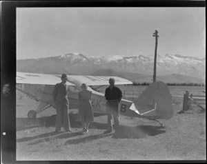 Two unidentified men and a woman, near an Auster ZK-AOB airplane, Sherwood Downs, Fairlie, Canterbury Region