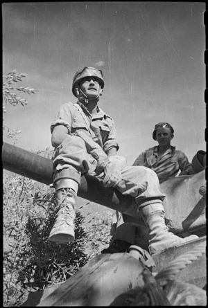 Member of a New Zealand tank crew views countryside while seated on the gun, Italy, World War II - Photograph taken by George Kaye