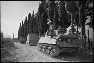 New Zealand transport and tank moving along tree lined road towards Florence, Italy, World War II - Photograph taken by George Kaye