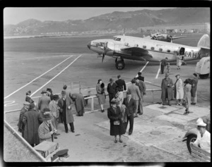 Passengers waiting to board aircraft Lockhead Lodestar ZK-AHX 'Karoro', Rongotai Airport (Wellington International Airport)