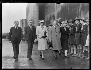The Honourable F Jones, left, the Honourable F Hackett, centre, and Mr AS Drakeford, with two unidentified women, walking past a row of Scouts, at the opening ceremony for British Commonwealth Pacific Airlines' trans Pacific service, at Whenuapai Airport, Auckland