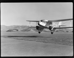 View of the NZ NAC (National Airways Corporation) De Havilland Dominie 'Tara' bi-plane ZK-AKS taking off from Omaka Airport, Blenheim, Marlborough Region