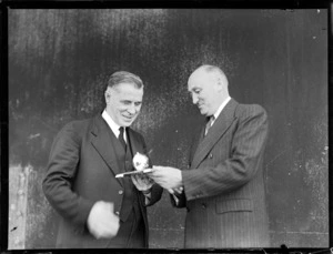 The Honourable F Jones, left, being presented with an object [trophy?] by Mr AW Coles, at inguration ceremony for British Commonwealth Pacific Airlines' trans Pacific service, Whenuapai Airport, Auckland