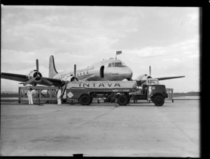 Douglas DC-4 Skymaster aeroplane 'Tatana' VH-AND, being refueled by an 'Intava' fuel tanker, at Whenuapai Airport, Auckland