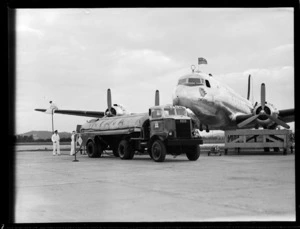 Douglas DC-4 Skymaster aeroplane 'Tatana' VH-AND, refueling from an 'Intava' fuel tanker, at Whenuapai Airport, Auckland