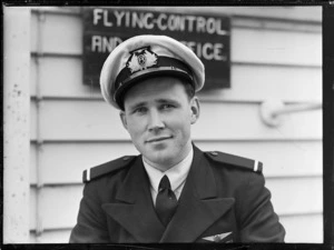 Portrait of NZ NAC ((National Airways Corporation) 2nd Officer Pilot K E George in uniform outside the [NAC?] building at Harewood Airport, Christchurch City, Canterbury Region