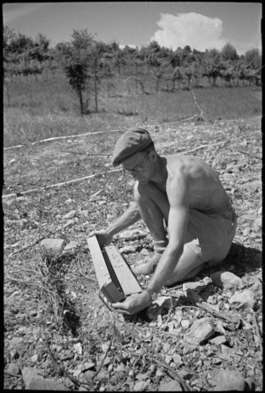 M W Glue carefully removes German anti-vehicle mine during advance to Florence in World War II - Photograph taken by George Kaye