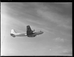 View of TAA (Trans Australian Airways) Skymaster DC4 passenger plane VH-TAB 'John Oxley' in flight over [Whenuapai Airport, Auckland City?]