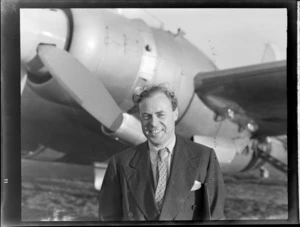 Portrait of Mr Summers, the Publicity Agent for and standing in front of the visiting British Vickers Viking passenger plane G-AJJN, Whenuapai Airport, Auckland City
