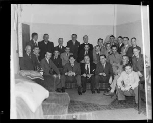 Unidentified group portrait of NZ NAC personnel being entertained by visiting British Vickers Viking passenger plane G-AJJN flight crew within an unknown building, Palmerston North, Manawatu-Whanganui Region