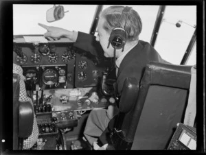 Portrait of Mr P Roberts sitting at the controls of visiting British Vickers Viking passenger plane G-AJJN