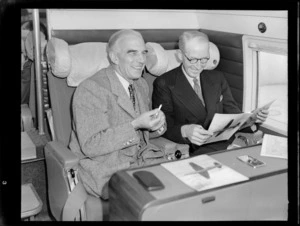 Portrait of Mr Dickson and Mr Salmon on visiting British Vickers Viking passenger plane G-AJJN looking over advertising material