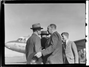 View of unidentified 'personalities' in front of the visiting British Vickers Viking passenger plane G-AJJN, [Whenuapai Airport, Auckland City?]