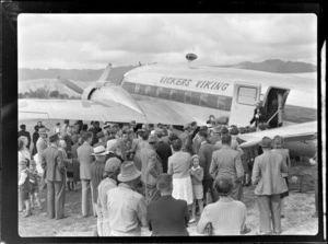 View of unidentified people inspecting the visiting British Vickers Viking passenger plane G-AJJN, Paraparaumu Airfield, Wellington Region