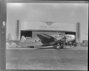 NZNAC (New Zealand National Airways Corporation) Lockheed Lodestar ZK-AHX airplane 'Karoro', outside a Union Airways of New Zealand Limited hangar, Dunedin