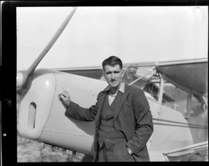 Portrait of S Robinson (Mid Canterbury Aero Club), next to an Auster airplane