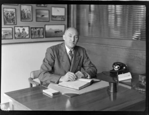 Portrait of Sir Arthur William Coles, of TAA (Trans Australia Airlines), sitting at desk