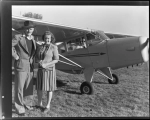 Mr and Mrs N Sutherland, members of the Otago Aero Club, standing next to Aircraft ZK-AOB Auster J1B Aiglet, unidentified man in cockpit of aircraft, location unidentified