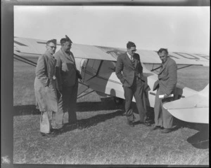 Auster tour, showing (L to R) T Ewart, M Wells, D Greig and C W F Hamilton, Irishman's Creek, Mackenzie District, Canterbury, next to a Auster ZK-AOB airplane