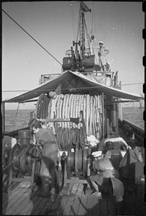 Lieutenant H L Mallitte, on bridge of World War II minesweeper, watches sweeps hauled in, Adriatic Sea - Photograph taken by George Bull