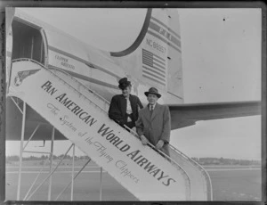 Portrait of PAWA passengers Mr and Mrs Claude Woollams on boarding steps of PAA Clipper Oriental NC 88957 passenger plane, [Whenuapai Airfield, Auckland?]