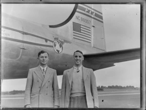 Portrait of PAWA passengers (L to R) Mr Noel Rudkin and Mr Arthur Lee in front of PAA Clipper Oriental NC 88957 passenger plane, [Whenuapai Airfield, Auckland?]