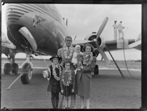 Portrait of PAA passenger arrivals Mr Carlton Pollard and family in front of refuelling PAA Clipper Celestial NC 88959 passenger plane, Whenuapai Airfield, Auckland