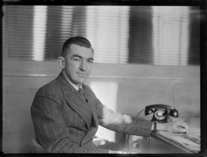 Portrait of Leo L White at his desk, Whites Aviation Office, Auckland City