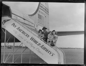Portrait of Mr and Mrs Rouda and family boarding PAA Clipper Celestial NC 88959 passenger plane, Whenuapai Airfield, Auckland